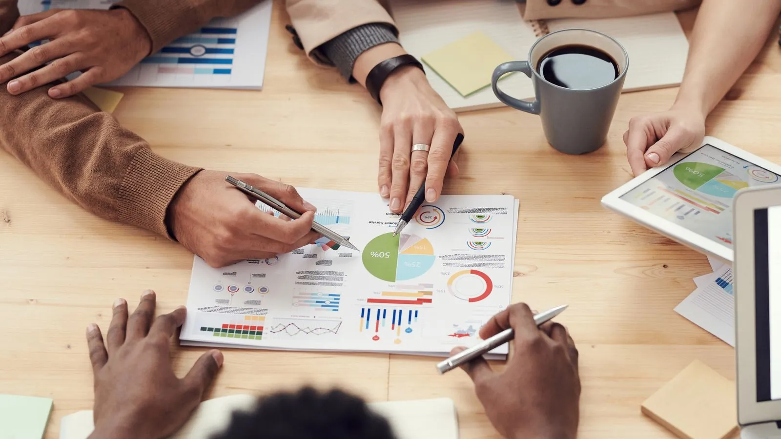 Team discussing printed charts and data at a meeting table