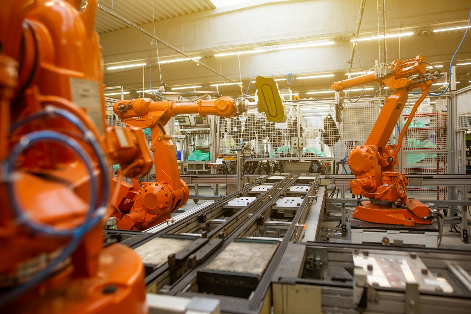 Pomarańczowe roboty przemysłowe na linii montażowej